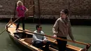 Gabriella Lazzari (kiri), anggota Row Venice, mengajarkan mendayung gondola bagi wisatawan di sebuah kanal di Venesia, Italia pada 16 Mei 2019. Pengalaman ini bisa dimiliki dengan sekitar Rp 1,37 juta per gondola selama 90 menit untuk empat orang yang dimulai pukul 10.00 pagi. (MARCO BERTORELLO/AFP)