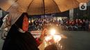 Massa menggelar aksi dengan membawa lilin dan doa bersama lintas agama di depan Gedung DPR, Jakarta, Kamis (16/3/2023). Dalam aksinya, mereka menuntut agar pimpinan DPR menetapkan RUU PPRT sebagai RUU INISIATIF DPR di Rapat Paripurna pada Selasa, 21 Maret 2023 mendatang. (Liputan6.com/Johan Tallo)
