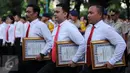 Anggota kepolisian membawa piagam penghargaan dari Kapolri di Polda Metro Jaya, Jakarta, Rabu (18/1). Penghargaan diberikan atas prestasi pengungkapan kasus perampokan Pulomas dengan cepat. (Liputan6.com/Gempur M Surya)