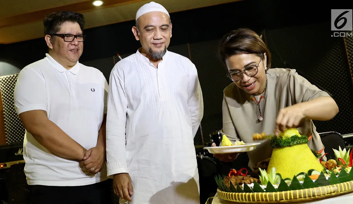 Penyanyi Ruth Sahanaya memotong tumpeng saat berlatih jelang konser tunggalnya di Jakarta, Jumat (16/3). Penyanyi berusia 51 tahun itu akan menggelar konser tunggal di Dewan Filharmonik Petronas (DFP) pada 21 Maret 2018. (Liputan6.com/Immanuel Antonius)