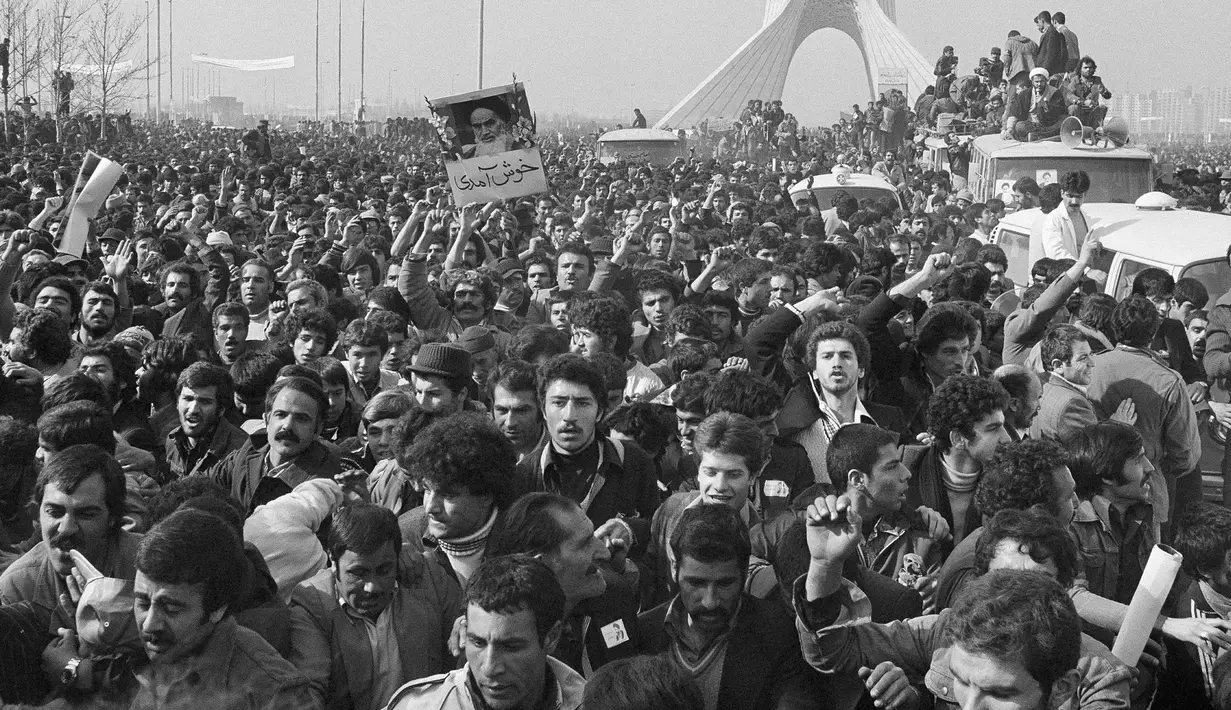Iring-iringan pemimpin spiritual Iran, Ayatollah Khomeini berada di antara kerumunan pendukungnya dekat Bandara di Teheran, Iran. 1 Februari 1979. Rezim kerajaan Iran di bawah Shah runtuh pada 11 Februari 1979. (AP Photo/TA, File)