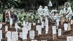 Petugas mengenakan APD lengkap saat proses pemakaman jenazah dengan protokol Covid-19 di TPU Bambu Apus, Jakarta, Kamis (28/1/2021). Pemprov DKI menyiapkan 6 lokasi baru untuk pemakaman jenazah pasien Covid-19 dengan total kapasitas 17.900 petak makam. (merdeka.com/Iqbal S Nugroho)