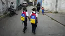 Anak-anak berjalan kaki ke sekolah pada hari pertama kembali ke kelas tatap muka sejak dimulainya pembatasan pandemi COVID-19 di Caracas, Venezuela, 25 Oktober 2021. (AP Photo/Ariana Cubillos)