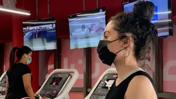 Seorang wanita mengenakan masker berlatih di sebuah gym di Riyadh, Arab Saudi (23/6/2020). Pemerintah Arab Saudi mulai membuka kembali kegiatan perekonomian setelah melonggarkan lockdown Covid-19. (AFP Photo/Rania Sanjar)
