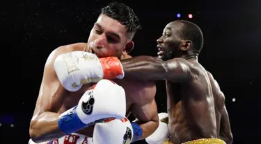 Terence Crawford (kanan) meninju Amir Khan pada perebutan gelar juara dunia tinju kelas welter WBO di Madion Square Garden, New York, Amerika Serikat, Minggu (21/4). Crawford berhasil mempertahankan gelar juara dunia tinju kelas welter WBO. (AP Photo/Frank Franklin II)