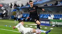 Gelandang Manchester City, Phil Foden, berebut bola dengan bek Olympique Marseille, Leonardo Balerdi, pada laga Liga Champions 2020/2021 di Stadion velodrome, Rabu (28/10/2020) dini hari WIB. Manchester City menang 3-0 atas Marseille. (AFP/Christophe Simon)