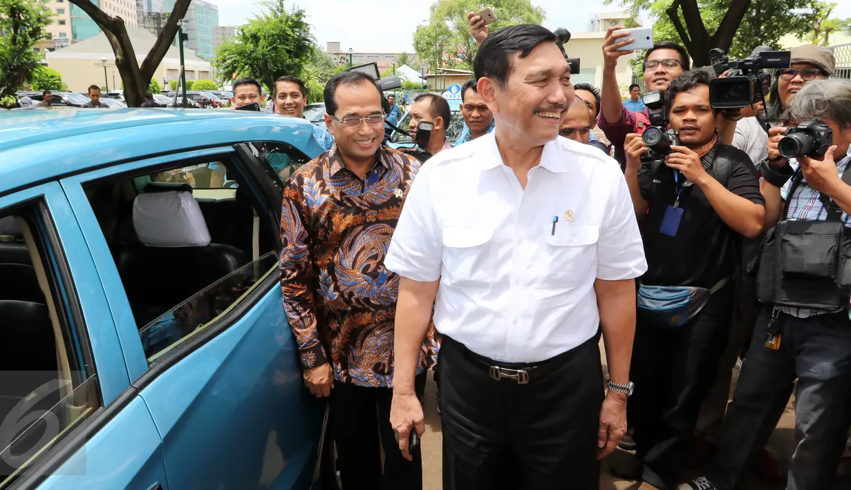 Menko Kemaritiman Luhut Binsar Panjaitan dan Menhub Budi Karya Sumadi di depan taksi pada acara Kolaborasi Blue Bird dan GO-JEK di Jakarta, Kamis (30/03). (Liputan6.com/Fery Pradolo)