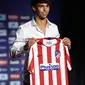 Gelandang Atletico Madrid, Joao Felix tersenyum saat berpose dengan jersey klub barunya selama perkenalan dirinya di Stadion Wanda Metropolitano, Madrid (8/7/2019). Joao Felix akan memakai nomor punggung 7 yang sebelumnya dipakai oleh Antoine Griezmann. (AFP Photo/Philippe Marcou)