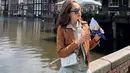 Berlibur ke Belanda, Cinta tampil dengan berbagai gayanya. Ia tampil mengenakan jaket kulit coklat dipadukan setelan warna hijau mint dari atasan crop dan celana cargo. [@claurakiehl]