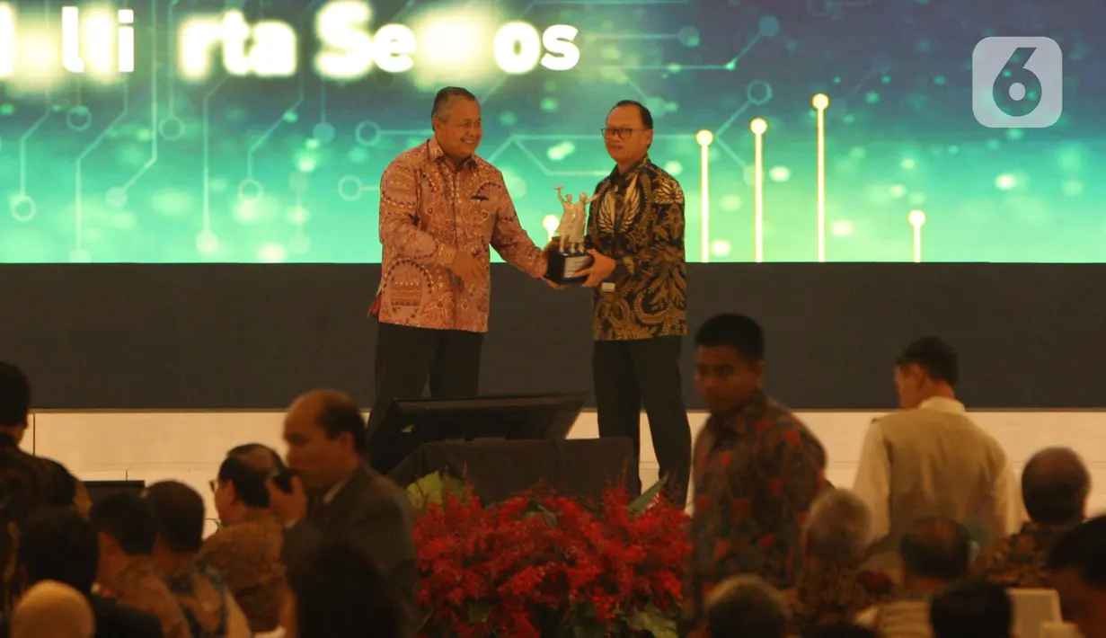 Gubernur Bank Indonesia Perry Warjiyo menyerahkan penghargaan BI Award 2019 kepada Direktur Manajemen Risiko BNI Rico Budidarmo dalam acara Pertemuan Tahunan Bank Indonesia (PTBI) 2019 di Jakarta, Kamis (28/11/2019). (Liputan6.com/Angga Yuniar)