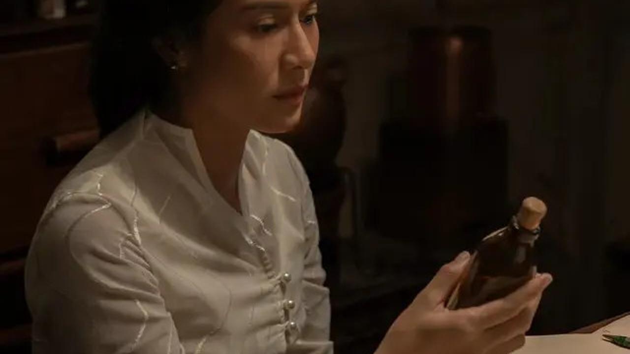 Dian Sastro tampil memukau dengan kebaya modern yang unik berdetail kancing pada foto ini.