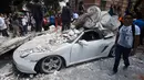 Sebuah mobil yang hancur tertimpa bangunan setelah gempa mengguncang Kota Meksiko (19/9). Gempa berkekuatan 7,1 Skala Richter mengguncang Ibu Kota Mexico City. (AFP Photo/Alfredo Estrella)