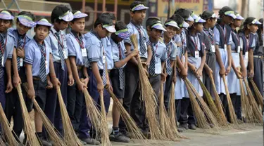 Sejumlah pelajar India membawa sapu saat mengambil bagian dalam 'Swachh Bharat Abhiyan' atau kampanye kebersihan di Hyderabad (12/2). Kampanye ini bertujuan untuk membersihkan jalanan dan infrastruktur di kota-kota India. (AFP Photo/Noah Seelam)