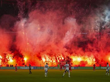Pendukung FC Twente menyalakan suar dan kembang api menjelang dimulainya babak kedua pertandingan Liga Europa 2024/2025 melawan Besiktas di De Grolsch Veste stadium, Enschede, Belanda, Jumat (31/01/2025) dini hari WIB. (AP Photo/Peter Dejong)
