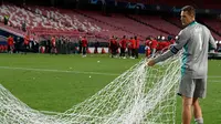 Kiper Bayern Munchen, Manuel Neuer membawa jaring gawang saat merayakan timnya meraih trofi Liga Champions usai mengalahkan PSG pada pertandingan final di stadion Luz di Lisbon (23/8/2020). Munchen menang tipis atas PSG 1-0. (AFP/Lluis Gene)