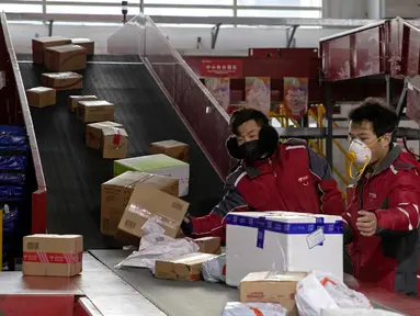 Kurir sibuk memilah paket di pusat distribusi di Beijing, China, Selasa (18/2/2020). Wabah virus corona atau COVID-19 membuat warga memilih untuk tinggal di rumah dan memanfaatkan jual beli secara online. (AP Photo/Ng Han Guan)
