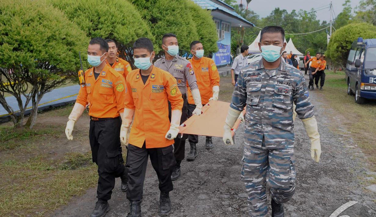 Tim SAR gabungan membawa tandu untuk memindahkan jenazah penumpang Pesawat AirAsia QZ8501 dari KRI Banda Aceh menggunakan helikopter Basarnas tiba di Lanud Iskandar Pangkalan Bun, Kalteng, Rabu (7/1/2015). (Liputan6.com/Andrian M Tunay)