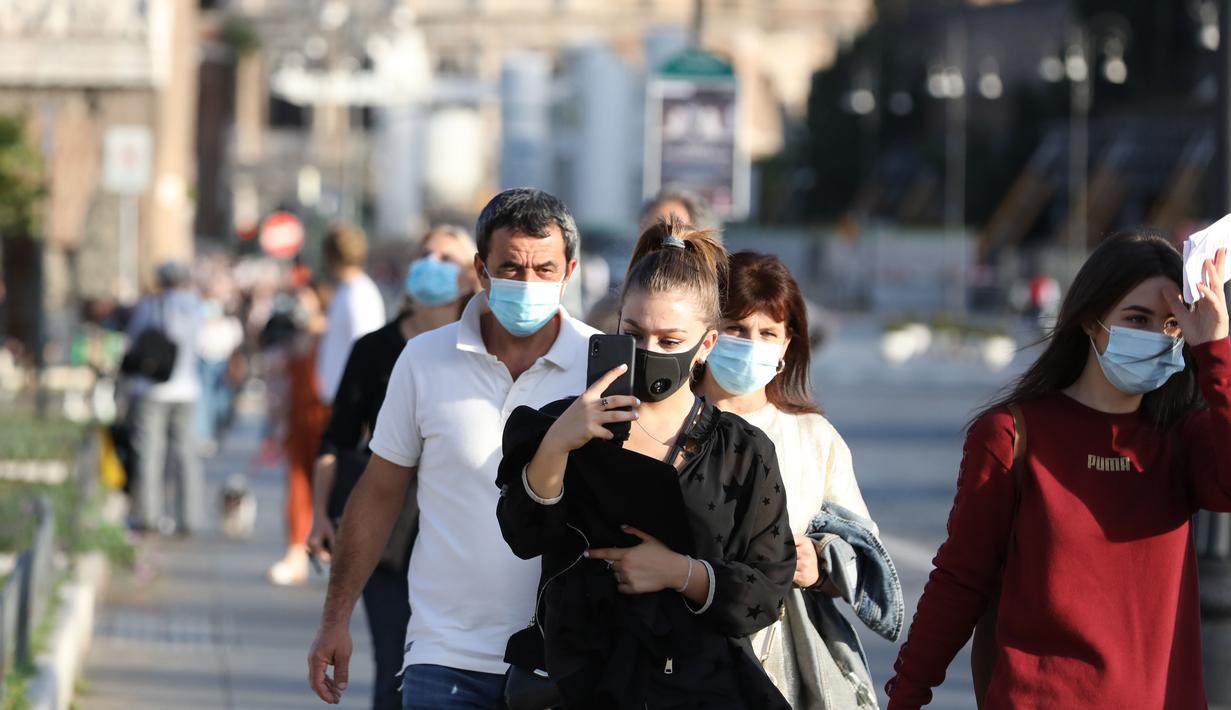Orang-orang yang memakai masker terlihat di Via dei Fori Imperiali di Roma, Italia pada 6 Oktober 2020. Lima wilayah di Italia selatan memberlakukan peraturan wajib memakai masker, bahkan untuk orang-orang di ruang terbuka. (Xinhua/Cheng Tingting)