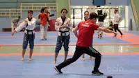 Pelatih asal Korea memberikan arahan kepada Tim putri Taekwondo Indonesia yang ikut kategori Poomsae saat berlatih gerakan dasar di GOR Popki, Cibubur (13/7/2017). (Bola.com/Nicklas Hanoatubun)