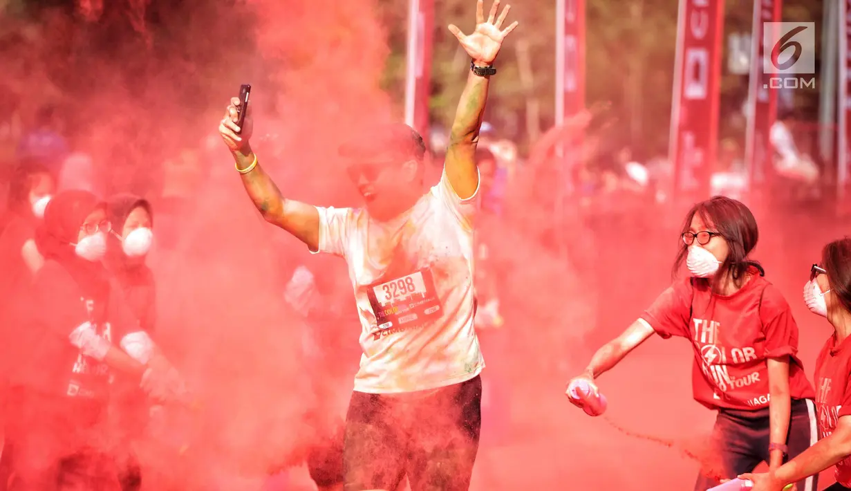 Seorang peserta mengikuti lari santai The Color Run di kawasan komplek Gelora Bung Karno, Jakarta, Minggu (16/9). The Color Run Mengusung tema 'Hero Tour', mengajak dan mendorong masyarakat untuk hidup. (Liputan6.com/Faizal Fanani)