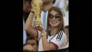 Seorang wanita suporter Jerman tampak memegang trofi Piala Dunia, Brasil, Senin (14/7/14). (AFP/JUAN MABROMATA)