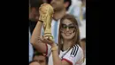 Seorang wanita suporter Jerman tampak memegang trofi Piala Dunia, Brasil, Senin (14/7/14). (AFP/JUAN MABROMATA)