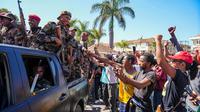 Tentara disambut oleh warga yang berkumpul dalam sebuah upacara untuk mengenang para demonstran yang tewas dalam aksi protes anti-pemerintah baru-baru ini di Antananarivo, Madagaskar, pada Minggu, (12/10/2025). (Dok. AP/Mamyrael)