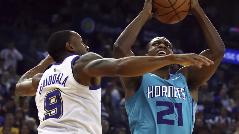 Andre Iguoadala menjaga pemain Hornets Treveon Graham