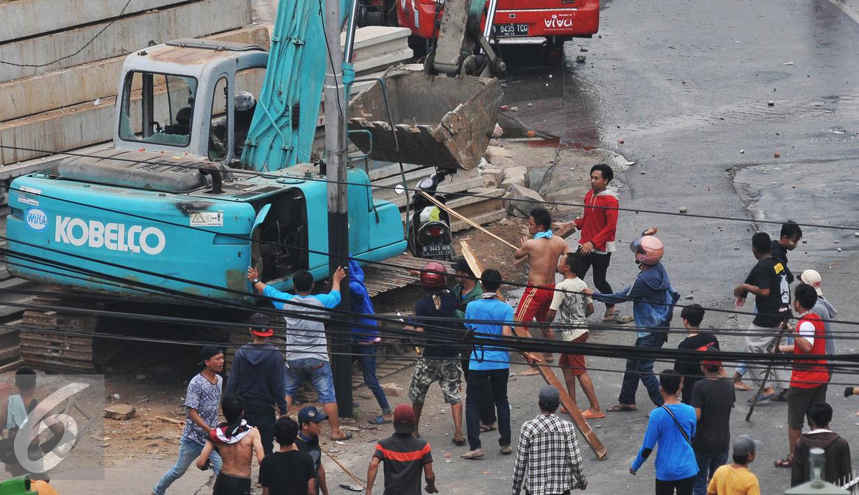 Sebuah alat berat di rusak massa saat kericuhan penggusuran Kampung Pulo, Jakarta, Kamis (20/8/2015). Penggusuran permukiman Kampung Pulo yang dilakukan oleh 2.200 personel gabungan untuk normalisasi Sungai Ciliwung. (Liputan6.com/Herman Zakharia)