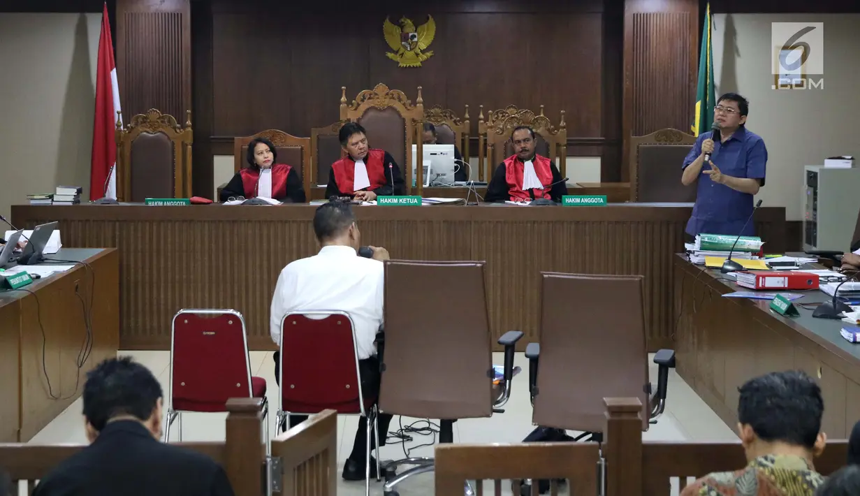 Terdakwa dugaan menghalangi proses penyidikan KPK, Lucas (kanan) memberi pertanyaan kepada salah satu saksi ahli pada sidang lanjutan di Pengadilan Tipikor, Jakarta, Kamis (21/2). Sidang mendengar dua saksi ahli. (Liputan6.com/Helmi Fithriansyah)