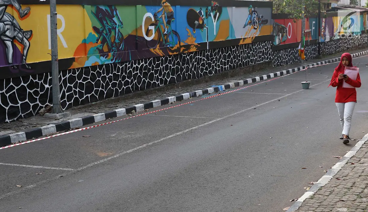 Mahasiswa melintas di depan mural bertema Asian Games 2018 di kawasan Universitas Negeri Jakarta, Kamis (16/8). Mural karya mahasiswa seni rupa tersebut dibuat dalam rangka menyambut Asian Games 2018. (Liputan6.com/Immanuel Antonius)