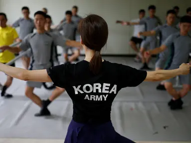 Instruktur balet wanita saat melatih para tentara Korsel belajar tari balet di sebuah pangkalan militer di dekat zona demiliterisasi yang memisahkan kedua negara Korsel dan Korut di Paju, Korea Selatan, (13/7). (REUTERS/Kim Hong-Ji)