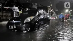 Sebuah mobil terendam saat banjir melanda kawasan Cipinang, Jakarta Timur, Minggu (23/2/2020) dini hari. Hujan deras yang mengguyur Jakarta dan sekitarnya sejak Sabtu malam ditambah buruknya drainase menyebabkan ratusan rumah di Cipinang terendam banjir. (merdeka.com/Iqbal S. Nugroho)