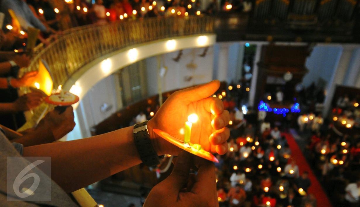 Umat Kristiani menyalakan lilin pada misa malam Natal di Gereja Immanuel, Jakarta  Sabtu (24/12). Perayaan natal berlangsung khidmat. (Liputan6.com/Angga Yuniar)