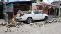 Sebuah mobil tertimbun bagian tembok yang roboh saat terjadi gempa bumi di Les Cayes, Haiti, Sabtu (14/8/2021). Wilayah Negara Haiti diguncang gempa berkekuatan magnitudo 7,1 pada Sabtu, 14 Agustus 2021 pukul 08.29.10 waktu setempat yang menewaskan lebih dari 300 jiwa. (AP Photo/Delot Jean)