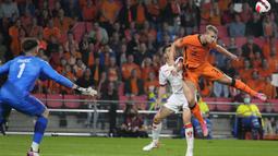 Bek timnas Belanda, Matthijs de Ligt menyundul bola saat kiper Montenegro Matija Sarkic mencoba menghalau pada laga lanjutan kualifikasi Piala Dunia 2022 di Stadion Phillips, Minggu (5/8/2021) dini hari WIB. Belanda sukses menghantam Montenegro dengan skor 4-0. (AP Photo/Peter Dejong)