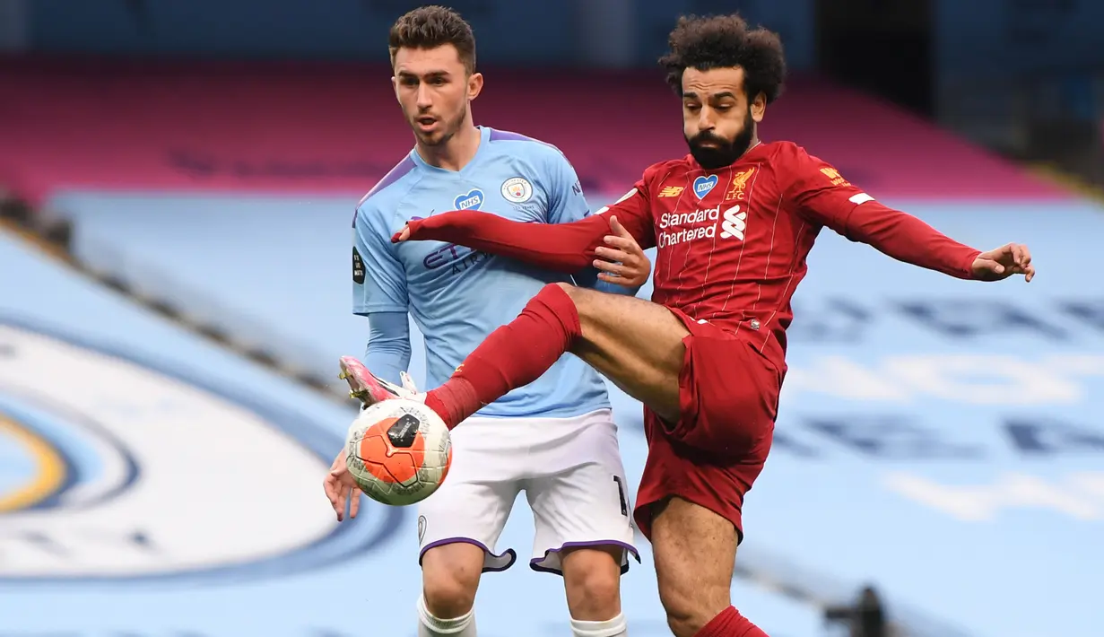Penyerang Liverpool, Mohamed Salah, berebut bola dengan bek Manchester City, Aymeric Laporte, pada laga lanjutan Premier League pekan ke-32 di Stadion Etihad, Jumat (3/7/2020) dini hari WIB. Manchester City menang 4-0 atas Liverpool. (AFP/Laurence Griffiths/pool)