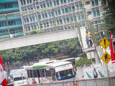 Pekerja sedang menyelesaikan Jembatan Penyeberangan Orang (JPO) di Bundaran HI, Jakarta, Selasa (26/8/14). (Liputan6.com/Faizal Fanani)