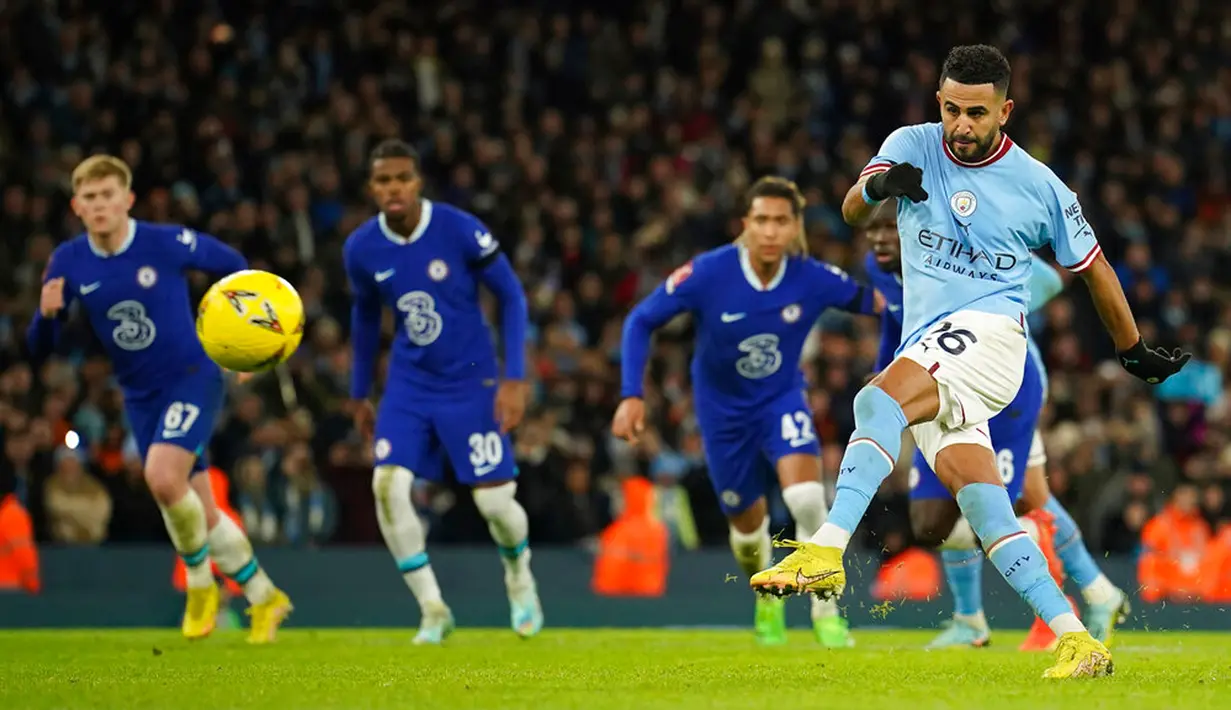 Pemain Manchester City Riyad Mahrez (kanan) menendang bola saat melawan Chelsea pada pertandingan sepak bola Piala FA di Etihad Stadium, Manchester, Inggris, 8 Januari 2023. Manchester City mengalahkan Chelsea dengan skor 4-0. (AP Photo/Dave Thompson)