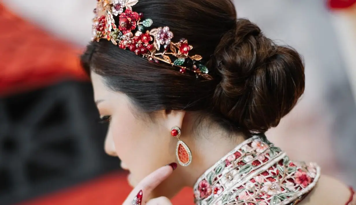 Pemanis pada penampilan Tina Toon adalah hair piece berupa bando dari bunga yang serasi dengan bordiran pada cheongsam yang dikenakannya. Foto: Instagram.
