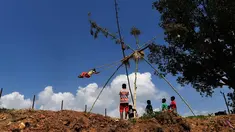 Anak-anak bermain di ayunan khas negara Nepal di Lalitpur pinggiran kota Kathmandu, Nepal (26/9). Ayunan yang dikenal dengan sebutan 'Dashain Ping' ini bisa dimainkan orang-orang dari segala usia. (AFP Photo/Prakash Mathema)