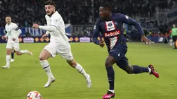 Bek Paris Saint-Germain (PSG) Presnel Kimpembe dan bek Olympique Marseille Jonathan Clauss  berusaha mengejar bola pada babak 16 besar Coupe de France atau Piala Prancis 2022-23 di Stade Velodrome, Kamis (9/2/2023) dini hari WIB. PSG tampil tanpa Kylian Mbappe yang cedera. Namun, Lionel Messi dan Neymar ada di jajaran pemain yang menjadi starter. (AP Photo/Laurent Cipriani)