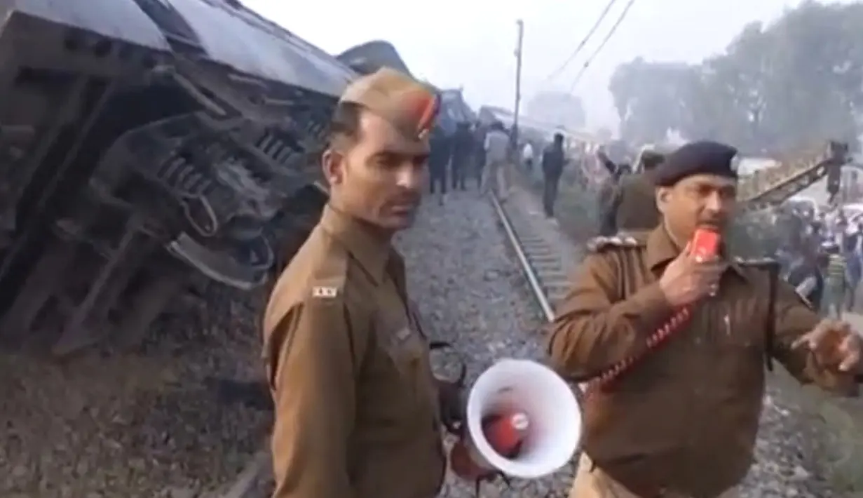Petugas memberi instruksi saat proses evakuasi tergelincirnya kereta Indian Express di Negara Bagian Uttar Pradesh, India, Minggu (20/11). Sebagian besar korban berada di dua gerbong dekat mesin kereta, yang terbalik dan rusak parah. (ANI/via REUTERS)