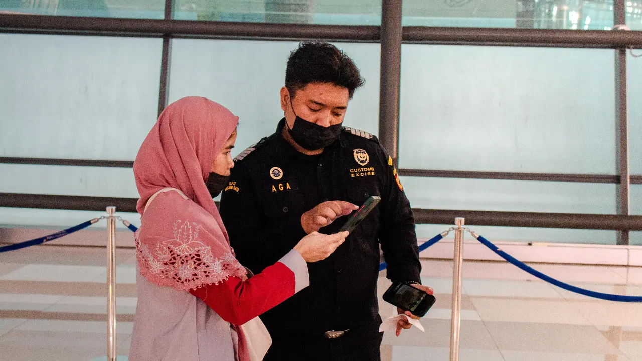 Petugas Bea Cuka  tengah memandu penumpang menggunakan electronic customs declaration (e-CD). (Istimewa)