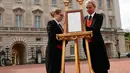 Senior footman Olivia Smith dan footman Heather McDonald saat memajang pengumuman kelahiran bayi baru kerajaan di halaman depan Istana Buckingham, London, Inggris, Senin (23/4). Kate Middleton melahirkan di RS St. Mary. (Pool Photo via AP)