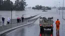Sebuah kendaraan darurat memblokir akses ke Jembatan Windsor yang banjir di pinggiran Sydney, Australia, Senin (4/7/2022). Ratusan rumah terendam di dalam dan sekitar kota terbesar Australia itu dalam keadaan darurat banjir yang berdampak pada 50.000 orang, kata para pejabat. (AP Photo/Mark Baker)