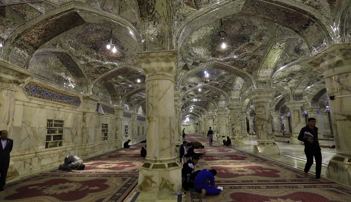 Sejumlah orang berdoa dan salat di dalam masjid Imam Ali di kota Najaf, Irak (23/1). Masjid ini memiliki kapasitas yang dapat menampung 900.000 jamaah. (AFP Photo/Haidar Hamdani)
