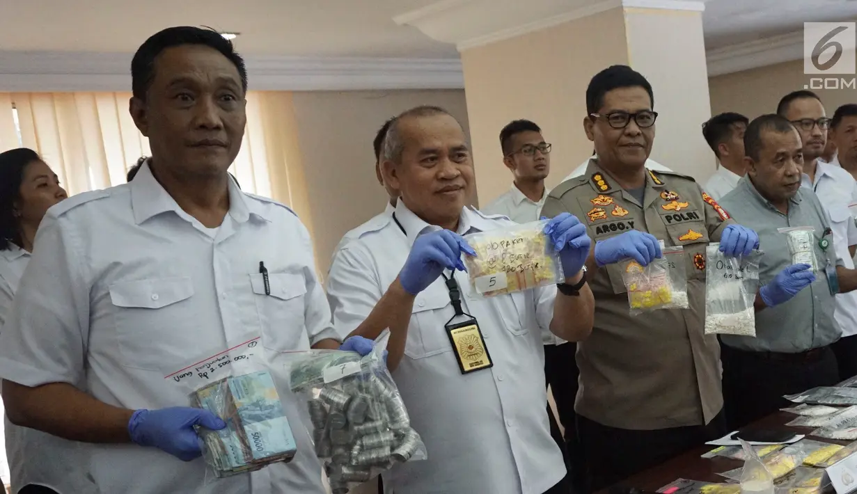 Kabid Humas Polda Metro Jaya Kombes Pol Argo Yuwono (tengah) menunjukkan barang bukti dalam rilis kasus peredaran obat tanpa izin di Polda Metro Jaya, Jakarta, Kamis (7/2). (Liputan6.com/Herman Zakharia)