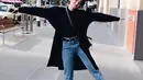 Bisa jadi inspirasi outfit liburan, padukan long coat warna hitam dengan turtleneck top dan boyfriend jeans. (Instagram/enzystoria)