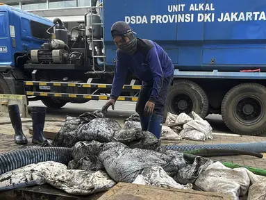 Petugas Dinas Tata Air Jakarta Selatan melakukan pengerukan endapan lumpur di gorong-gorong saluran air kawasan Blok M, Jakarta Selatan, Rabu (1/12/2021). Pengerukan dilakukan untuk mengantisipasi banjir di kawasan tersebut selama musim hujan. (Liputan6.com/Johan Tallo)